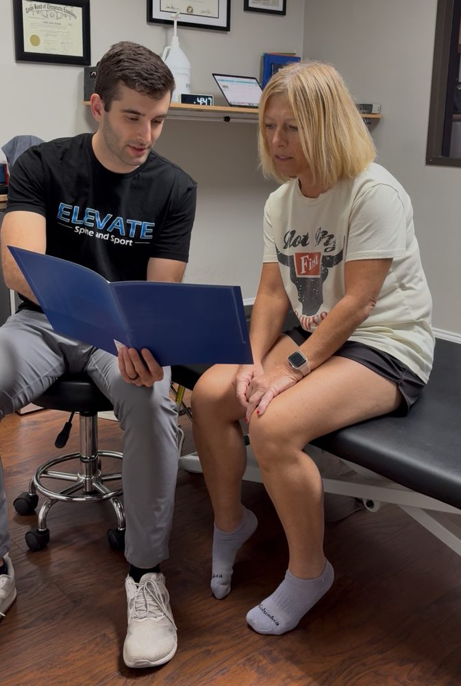 Dr. Caleb Strunk reviewing a care plan with a patient at Elevate Spine and Sport